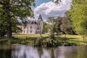 an old castle with a pond in front of it at Château Sénéjac in Le Pian-Médoc