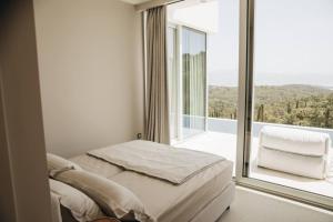 a bedroom with a bed and a large window at Luxury Villa Morello Korcula 2 with heated pool, gym, sauna in Korčula