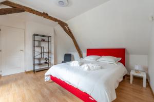 Un dormitorio con una cama grande con cabecero rojo. en Longère Spa & Bien-être, en La Chapelle-sur-Loire