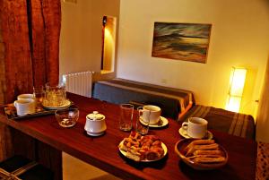 a wooden table with food and drinks on it at Al Sereno Hotel Spa in Tilcara