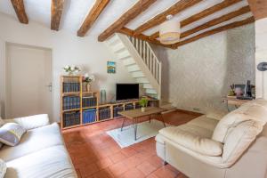 Una sala de estar con muebles blancos y una escalera. en Longère Spa & Bien-être, en La Chapelle-sur-Loire