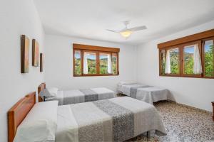 2 camas en una habitación con ventanas en La Casita de Rufo, en Granada