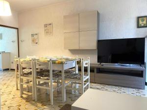 una cucina con un tavolo con sedie e una televisione di VILLETTA 8 - Premium Villas a Giulianova