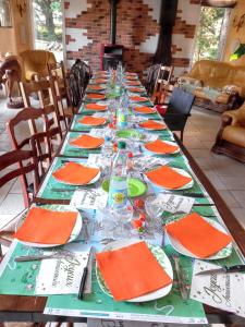 una mesa larga con platos y vasos. en Maison de 4 chambres avec jardin amenage et wifi a Saint Leonard a 1 km de la plage, en Saint-Léonard
