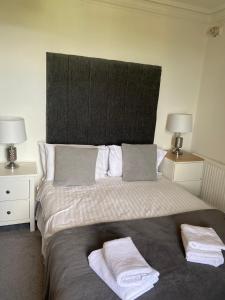 - une chambre avec un grand lit et des serviettes dans l'établissement Ellwyn House, à Édimbourg
