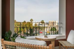 a balcony with a table and a glass of wine at Only YOU Hotel Málaga in Málaga