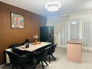 ein Esszimmer mit einem Tisch und schwarzen Stühlen in der Unterkunft VeroDeLux in Şelimbăr