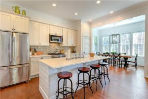a kitchen with a large island with bar stools at Spindrift by Seabrook Hospitality in Pacific Beach