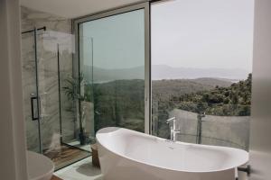 a bathroom with a tub and a glass window at Luxury Villa Morello Korcula 1 with 64 m2 Heated Pool, Gym, Sauna, for 8 guests in Korčula +45 photos