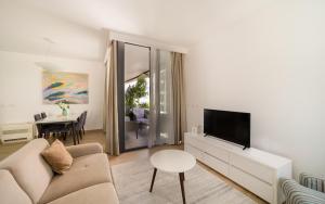 sala de estar con sofá, TV y mesa en Amare Luxury Apartments en Budva