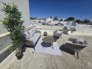 een terras met een tafel en stoelen en een tafel en een parasol bij Dias de sol in Fuzeta