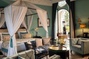 a bedroom with a canopy bed and a couch at Palais Ronsard Relais & Chateaux in Marrakesh