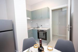 a kitchen with blue cabinets and a table with a bottle of wine at Apartment Kjara in Herceg-Novi