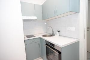 a small kitchen with white cabinets and a sink at Apartment Kjara in Herceg-Novi