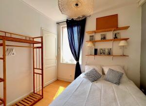 a bedroom with a bed and a window and a chandelier at Le Saint Lazare in Compiègne