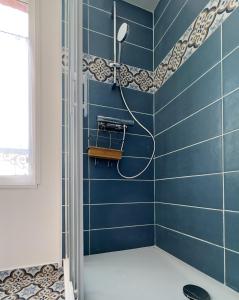 a blue tiled bathroom with a shower at Le Saint Lazare in Compiègne