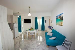 a living room with a blue couch and a table at Ammos Beach Apartment in Skaleta