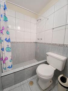 uma casa de banho branca com um WC e um chuveiro em Hotel Presidencial em Chiclayo