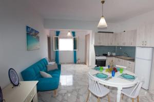 a living room with a blue couch and a table at Ammos Beach Apartment in Skaleta +34 photos