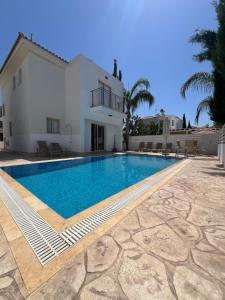 Villa con piscina frente a una casa en Palm Tree Villas, en Protaras