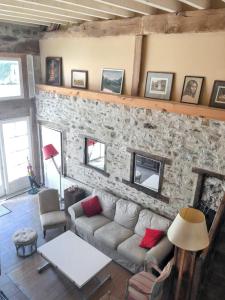 uma sala de estar com um sofá e uma parede de pedra em Maison de 4 chambres avec jardin clos et wifi a Souvigny em Souvigny