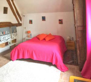 um quarto com uma cama com um cobertor rosa em Maison de 4 chambres avec jardin clos et wifi a Souvigny em Souvigny