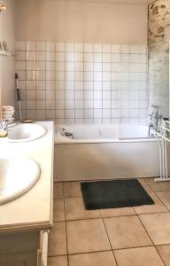 uma casa de banho com uma banheira e um lavatório em Maison de 4 chambres avec jardin clos et wifi a Souvigny em Souvigny