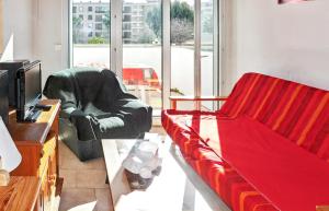 uma sala de estar com um sofá e uma cadeira em Appartement d'une chambre a Frejus a 300 m de la plage avec vue sur la ville piscine partagee et balcon em Fréjus