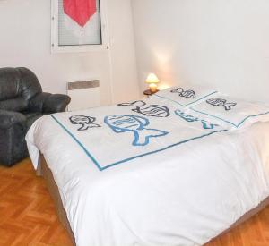 uma cama com um cobertor branco com desenhos em Appartement d'une chambre a Frejus a 300 m de la plage avec vue sur la ville piscine partagee et balcon em Fréjus
