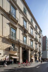 duży budynek z ludźmi idącymi przed nim w obiekcie Napolit'amo Hotel Principe w mieście Neapol