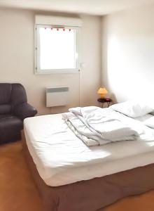 uma cama branca num quarto com uma janela em Appartement d'une chambre a Frejus a 300 m de la plage avec vue sur la ville piscine partagee et balcon em Fréjus