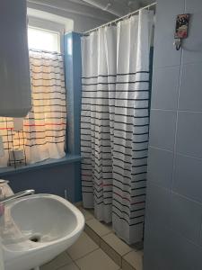 łazienka z umywalką i zasłoną prysznicową w obiekcie Tififi jak na Włoskiej prowincji w Pobierowie