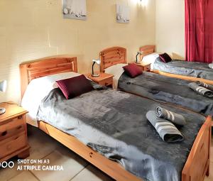 una camera con tre letti e un comodino di 3 bedrooms villa with sea view private pool and enclosed garden at Iz Zebbug a Qala