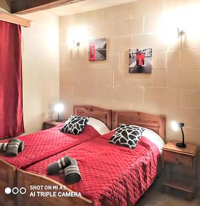 una camera con letto e piumone rosso di 3 bedrooms villa with sea view private pool and enclosed garden at Iz Zebbug a Qala