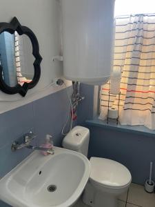 W łazience znajduje się umywalka, toaleta i lustro. w obiekcie Tififi jak na Włoskiej prowincji w Pobierowie
