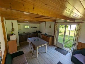 a kitchen and dining room with a table in a cabin at Couette et Tartinettes in Bretagne-dʼArmagnac