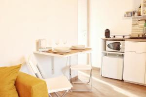 a small white kitchen with a table and a couch at La Casa dei Mori in Siracusa