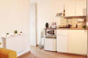 a kitchen with white cabinets and a microwave at La Casa dei Mori in Siracusa +44 photos
