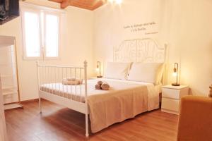 a bedroom with a white bed with two shoes on it at La Casa dei Mori in Siracusa