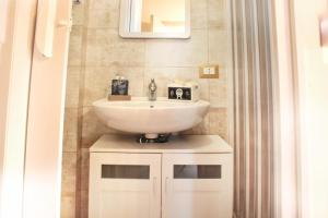 a bathroom with a white sink and a mirror at La Casa dei Mori in Siracusa