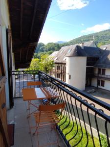 Un balcón con mesa y sillas y una vista. en Bel appartement proche Saint Lary Soulan, en Vielle-Aure