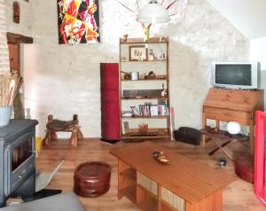 a living room with a tv and a table at Appartement de 2 chambres avec terrasse amenagee et wifi a Chenevrey et Morogne in Chenevrey-et-Morogne