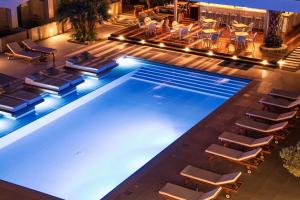 a large swimming pool with chairs and a table at Danae Hotel in Egina