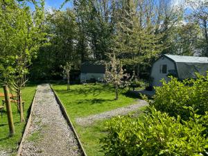 vistas a un jardín con un remolque y árboles en Penhallow House Glamping Retreat en Newlyn East