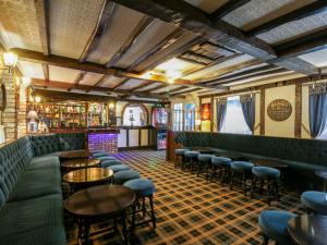 a bar with green booths and tables and chairs at Ivy in Filey