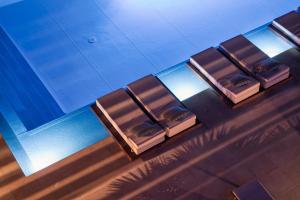 a row of chairs sitting next to a swimming pool at Danae Hotel in Egina