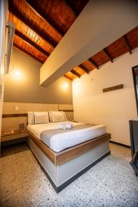 sypialnia z łóżkiem i telewizorem w obiekcie Mándala Botero Medellín w mieście Medellín