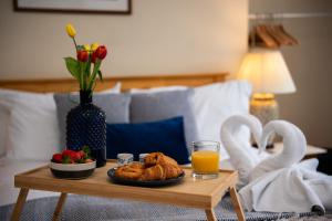 a table with a plate of bread and a glass of orange juice at Spacious River View Retreat Near Peak District in Matlock