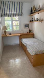 a bedroom with a bed with a desk and a window at Apartamento a pie de Playa in S'Agaro +13 photos