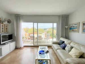 a living room with a couch and a television at Apartamento a pie de Playa in S'Agaro